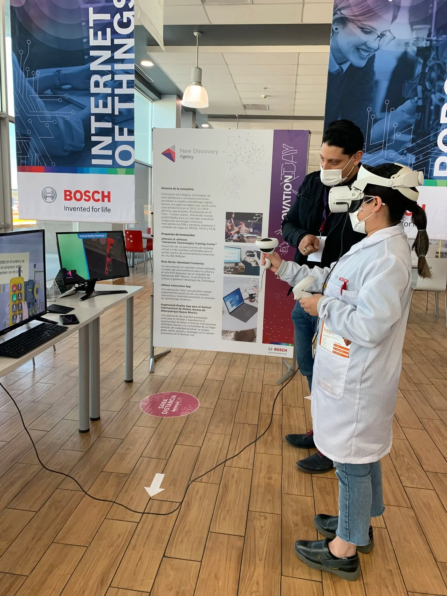 A visitor in a lab coat trying a virtual reality application at the New Discovery stand, Bosch Innovation Day