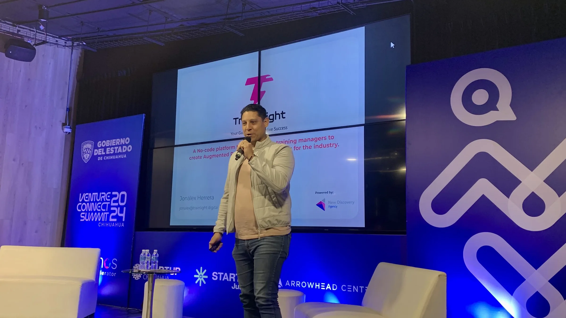 Jonalex Herrera on stage with the Trainlight title slide behind him